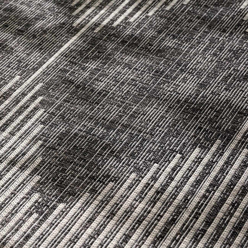 Close-up of the Stephan Area Rug showing a black, charcoal, and cream geometric pattern and woven texture. Texture
