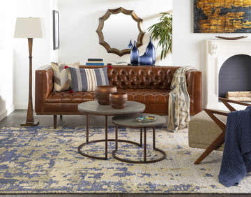 Living room scene with brown leather sofa and Eastvale Abstract Wool Rug in beige and blue. Roomscene-Rectangle