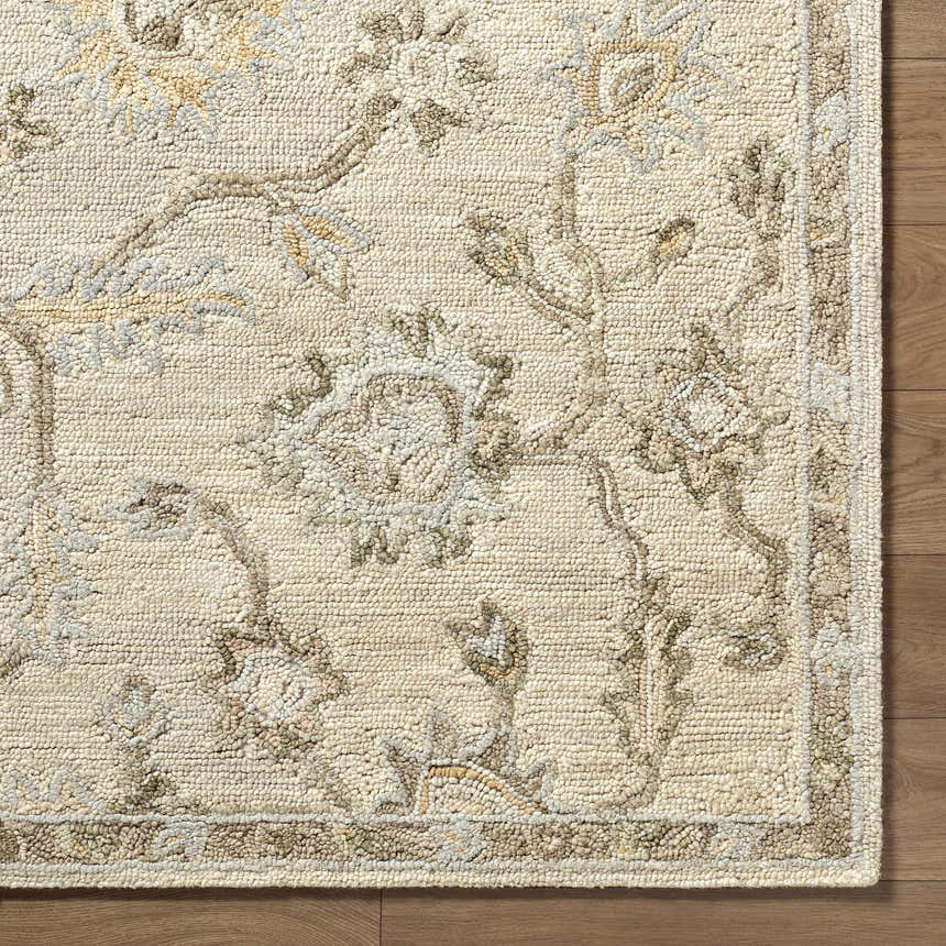 Close-up of the beige Adelle Tufted Oushak Area Rug showing the wool texture and traditional floral pattern. Corner
