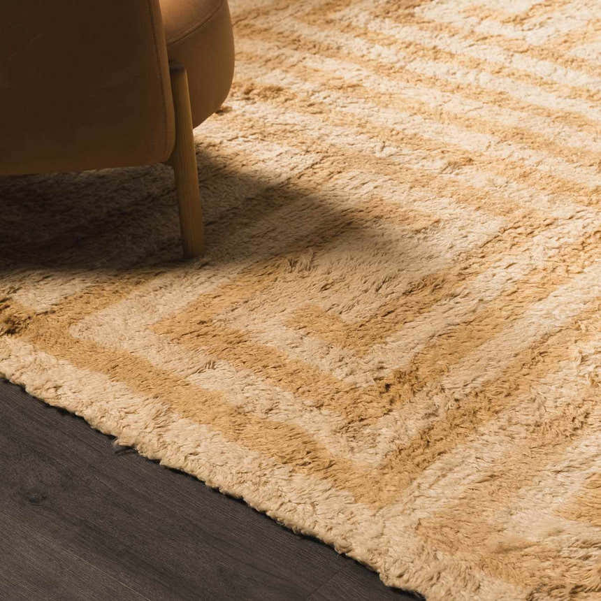 Close-up of the tan and light wood geometric pattern on the hand-tufted wool Wasim Area Rug. Styleshot