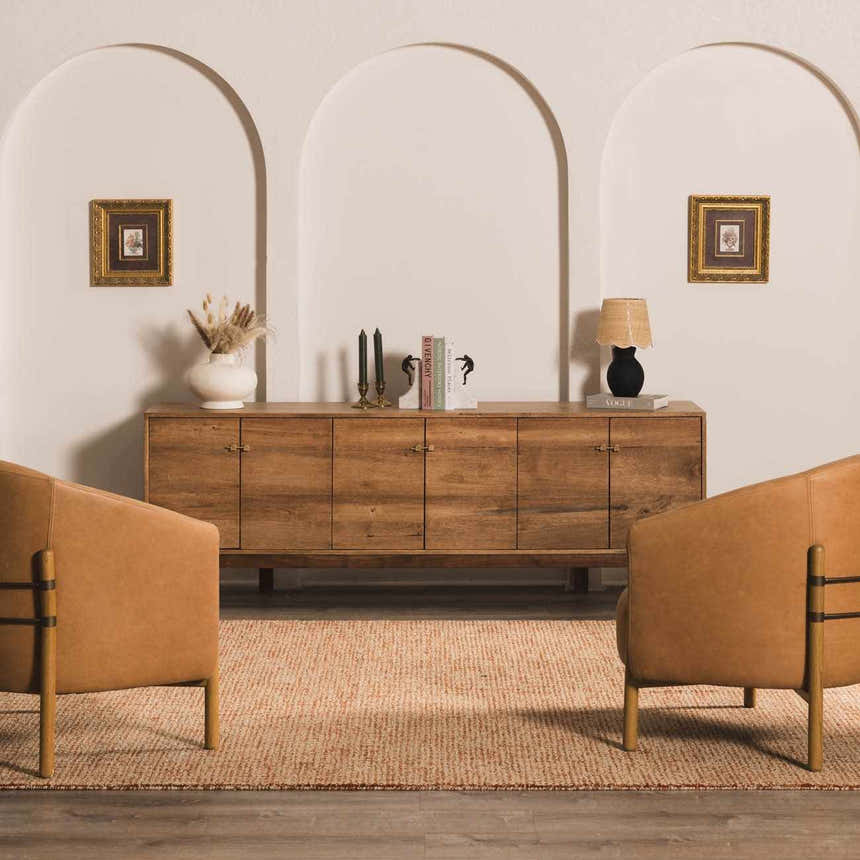 Living room scene with burnt orange Teresita Area Rug, wood cabinet, and two leather chairs. Roomscene-Rectangle
