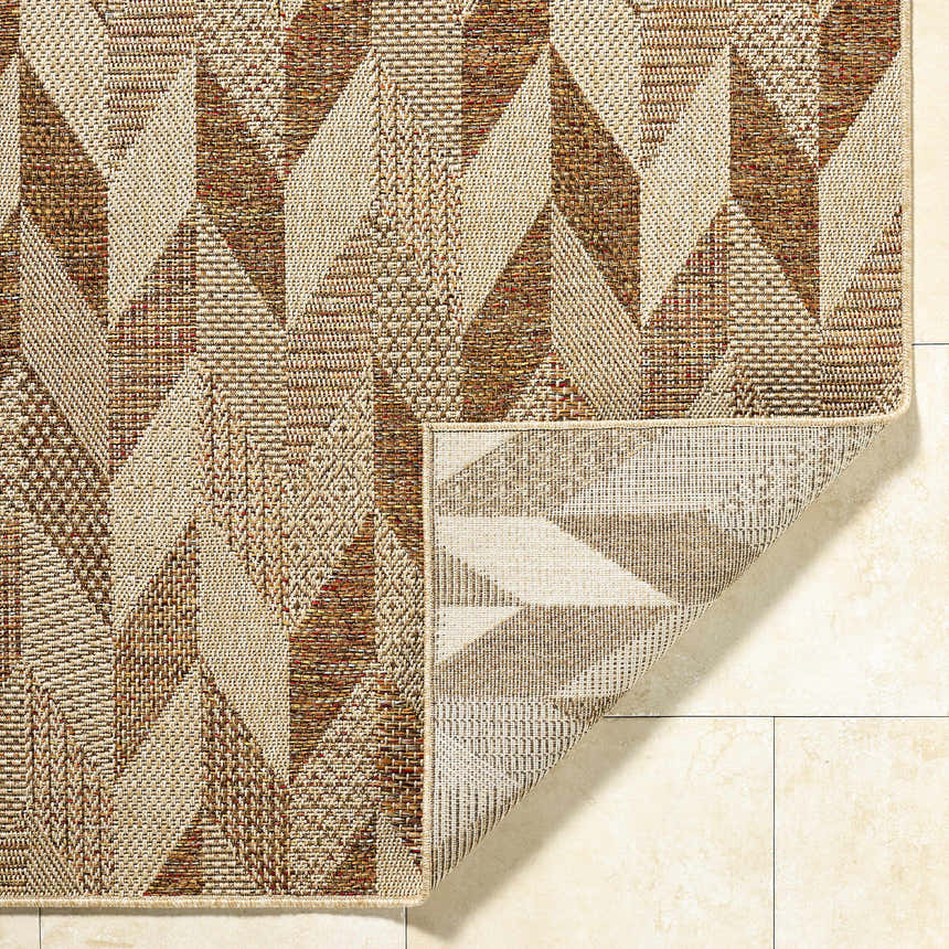 Close-up of the Andrea Burnt Sienna Area Rug, showcasing its beige, rust, and terracotta geometric pattern and woven texture. Fold