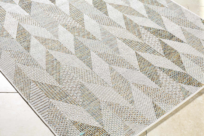 Close-up of the Andrea Ivory Area Rug featuring a geometric pattern in ivory, sage, sandstone, and sky blue hues. Corner