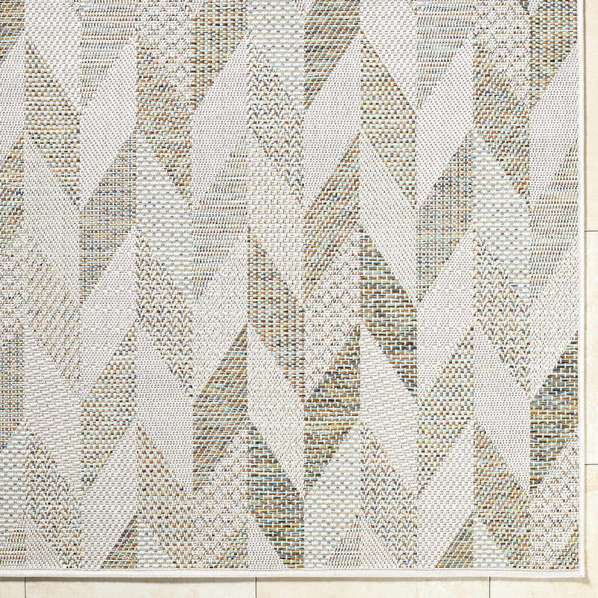 Close-up of the Andrea Ivory Area Rug featuring a geometric pattern in ivory, sage, sandstone, sky blue, and taupe. Corner
