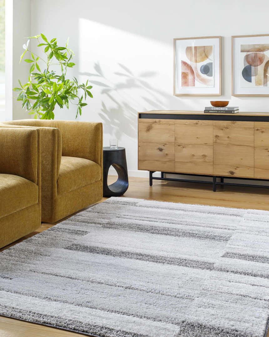 Living room scene with a light silver Tayla Shag Area Rug, mustard chairs, and a wood cabinet. Roomscene-Rectangle
