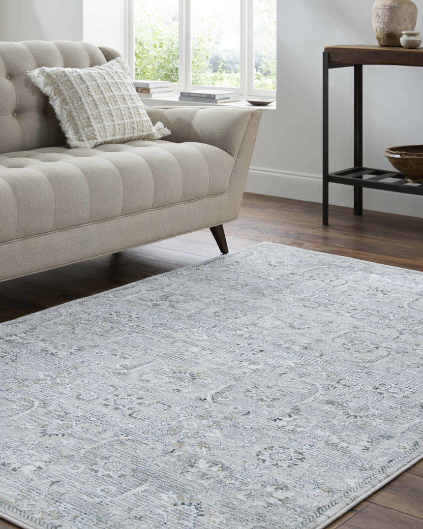 Living room scene with a silver gray Tariq Area Rug, beige sofa, wood floors, and natural light. Roomscene-Rectangle