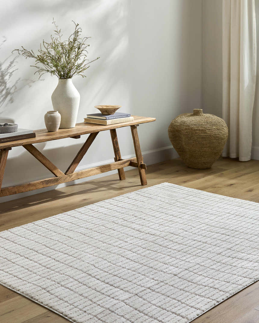 Entryway with a Cascade White Area Rug, wooden bench, vases, books, and woven basket. Farmhouse style. Roomscene-Rectangle