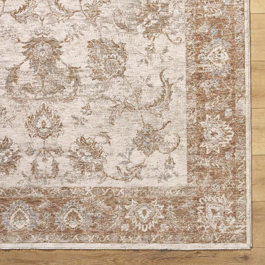 Close up of Tylie Blue Area Rug. Farmhouse style rug with cream, tan, and blue floral pattern. Corner