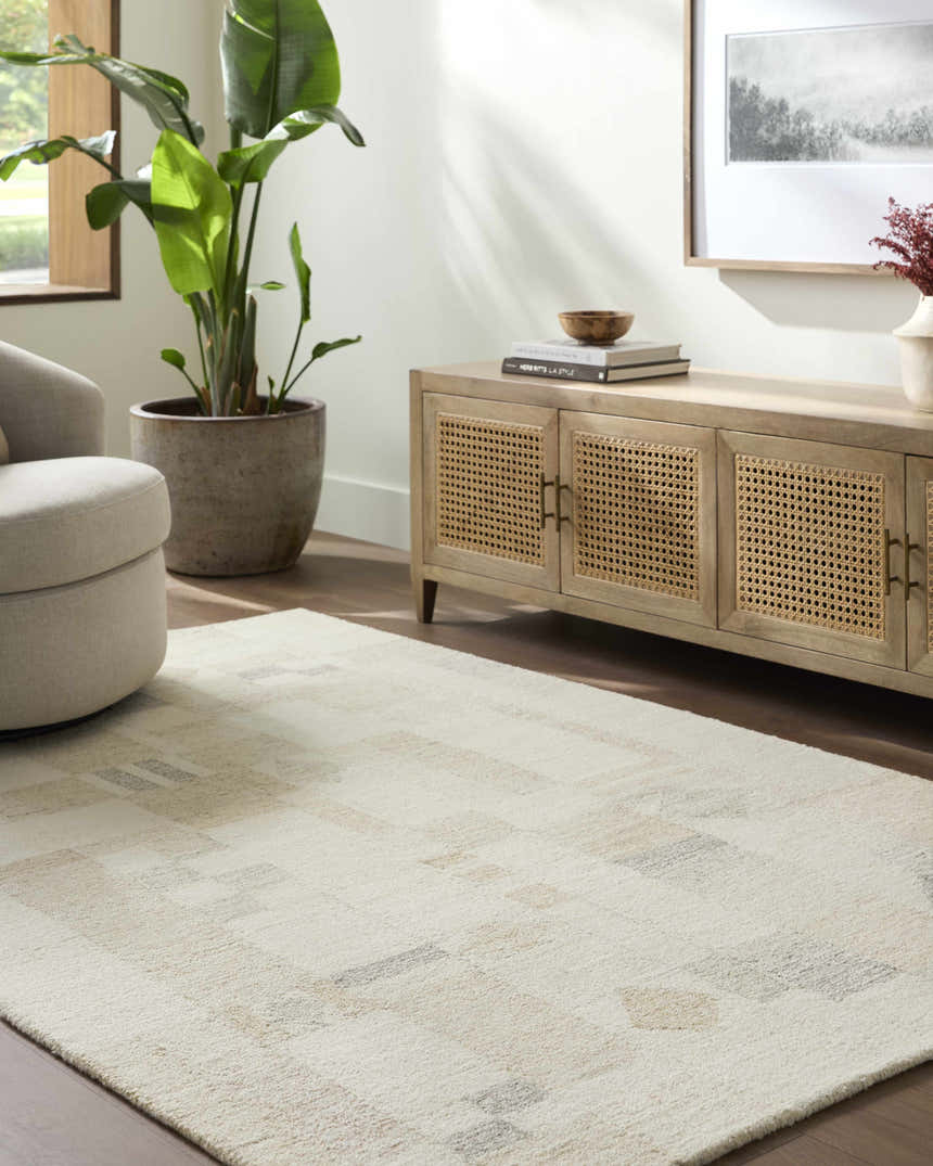 Living room scene with a light gray Tovah area rug, beige swivel chair, and light wood media cabinet. Roomscene-Rectangle