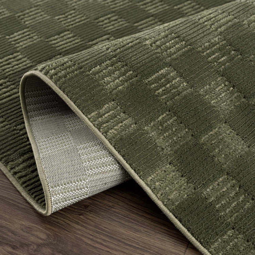 Close-up of the green Truls 3D Checkered Washable Rug showing its textured, checkered design and durable backing. Fold