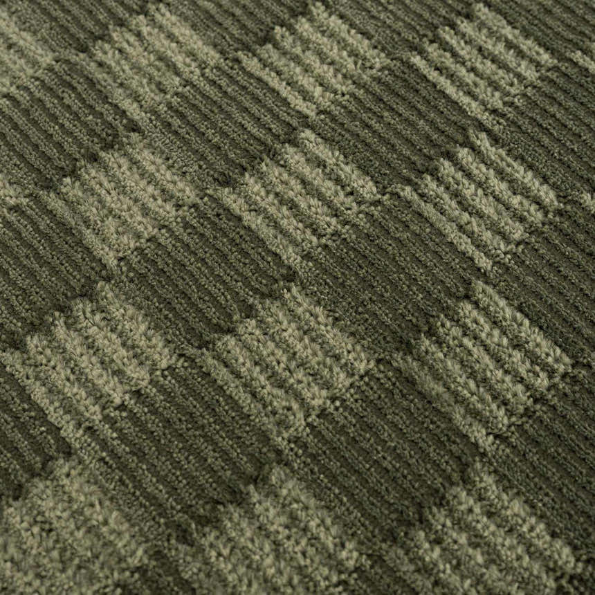 Close-up of the Truls 3D Checkered Washable Rug in Green, showing the textured, checkered design. Texture