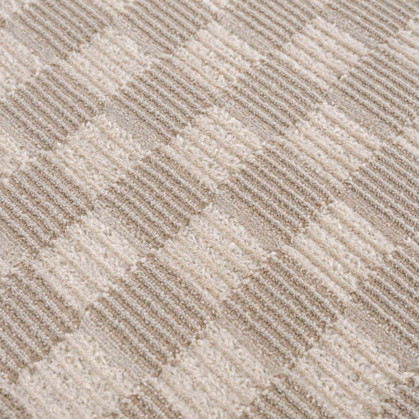 Close-up of the Truls 3D Checkered Washable Rug in Biscotti. Beige and cream checkered pattern, soft texture. Texture