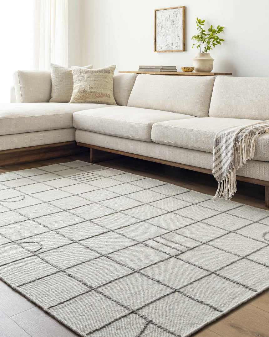 Living room with a Tieve Black & White Grid Wool Rug, cream sofa, and light wood accents. Roomscene-Rectangle