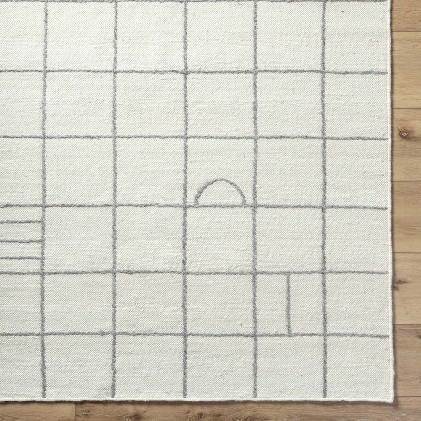 Close up of the Tieve Black & White Grid Wool Rug showing cream base and gray geometric grid pattern on wood floor. Swatch