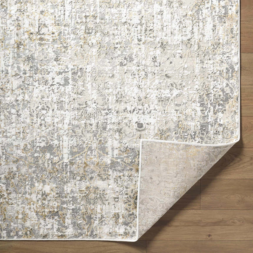 Close-up of the Tiago Area Rug, a contemporary rug in beige, charcoal, cream, and gray tones with an abstract pattern. Fold