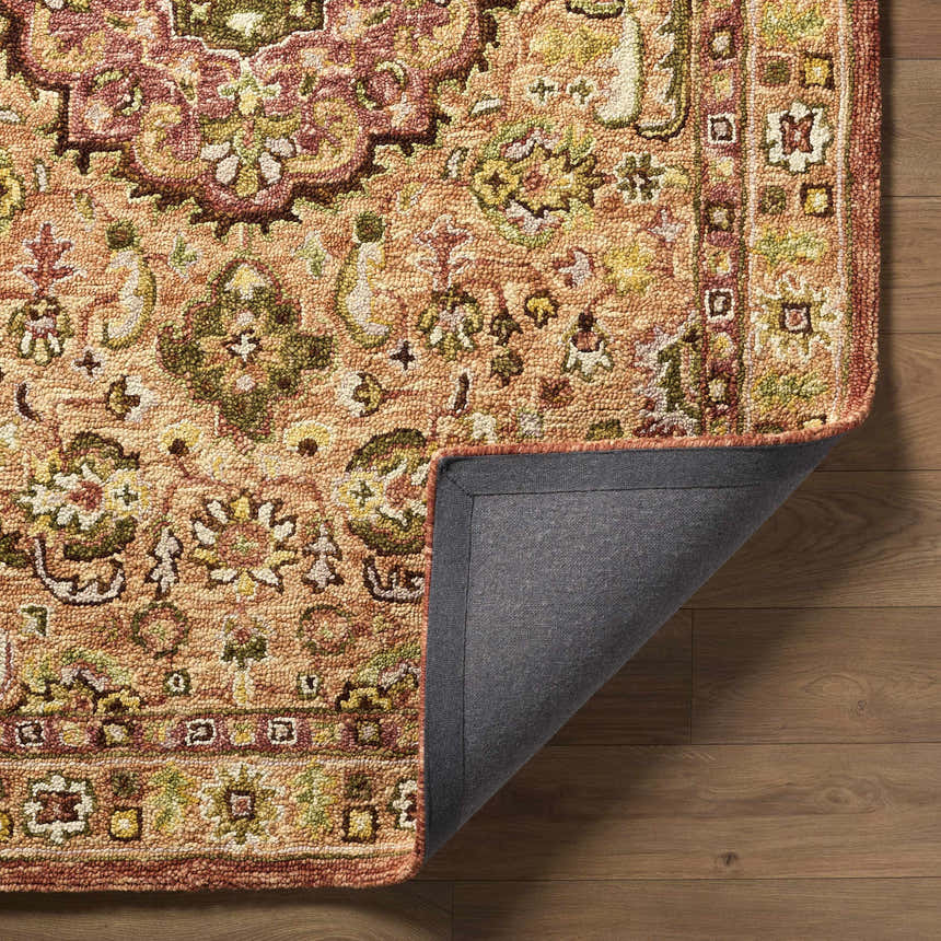 Close-up of the hand-tufted Annick Area Rug. Farmhouse style rug with a traditional floral pattern in peach, green, and brown tones. Fold