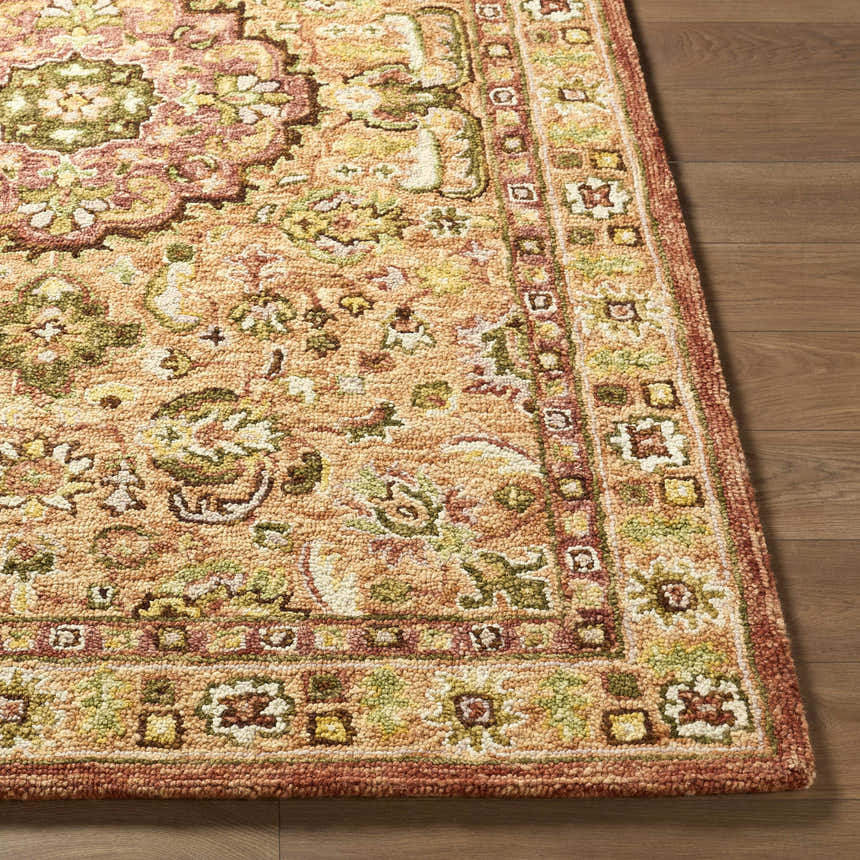 Close-up of the hand-tufted Annick Area Rug. Farmhouse style rug features a traditional floral pattern in peach, green, and cream. Front