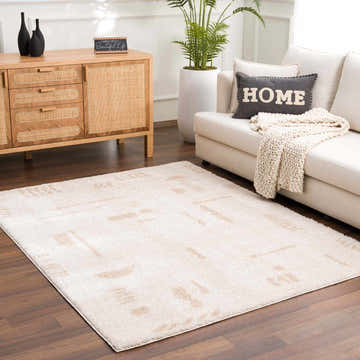 Living room scene with a beige Azriel Washable Area Rug, wood cabinet, white sofa, and houseplant. Contemporary style. Roomscene-Rectangle
