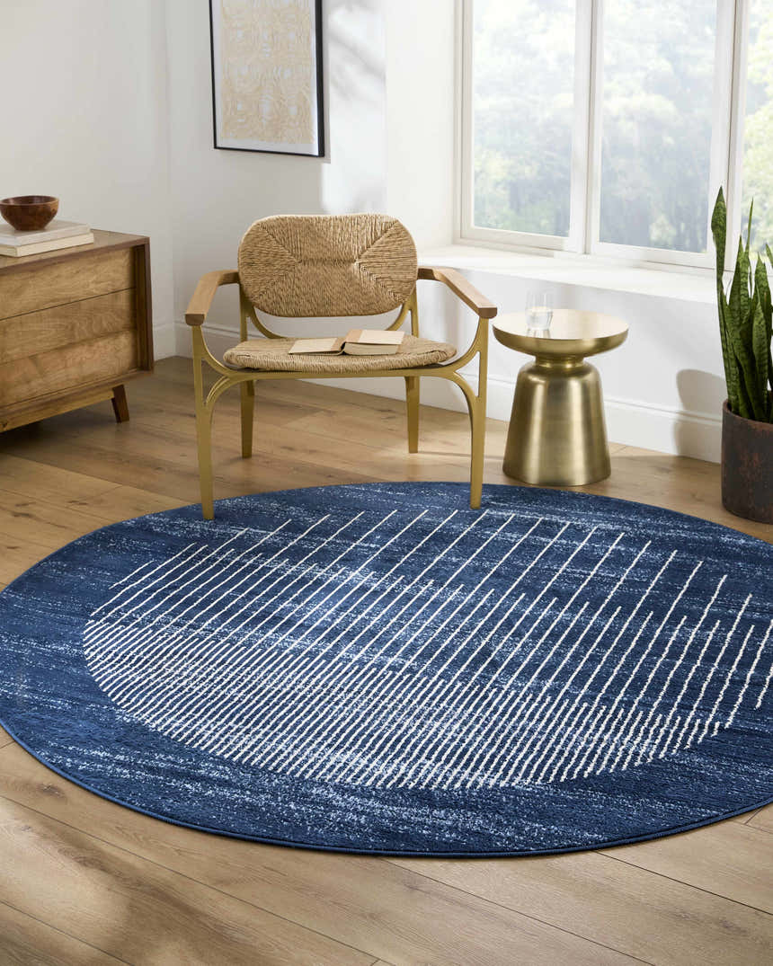 Living room with blue Urja Area Rug, round shape, white geometric pattern, wood floors, and natural light. Roomscene-Round