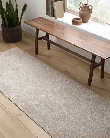 Hallway scene with a cream and sage Avalyn Area Rug under a wooden bench by a window. Roomscene-Runner
