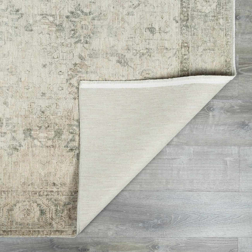 Close-up of Fetscher II Vintage Medallion Area Rug showing beige, light brown, olive, and peach colors and backing. Fold