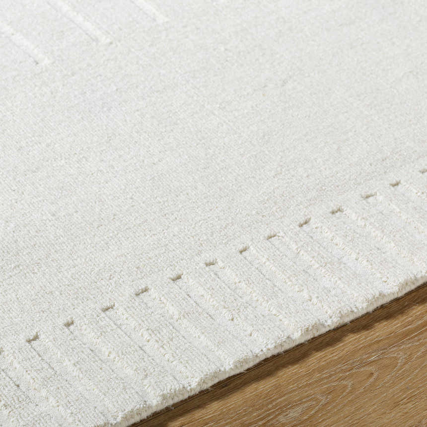 Close-up of the Arnona Off White Area Rug showing the textured wool and subtle geometric pattern. Texture