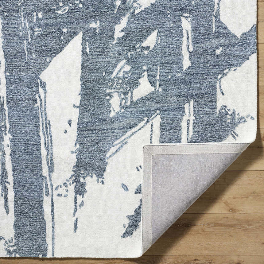 Close up of the Viven Slate Blue Area Rug showing the wool texture and abstract slate blue and white pattern. Fold