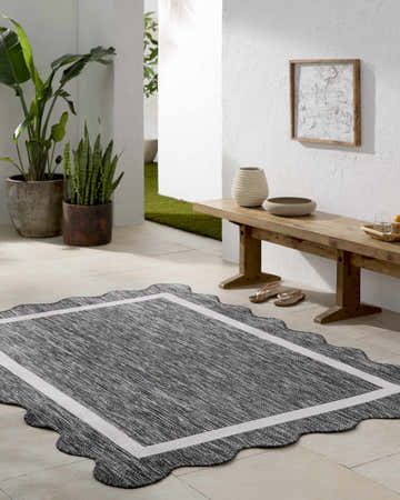 Styled patio with a Varro Black Area Rug, wood bench, potted plants, and neutral decor. Roomscene-Rectangle