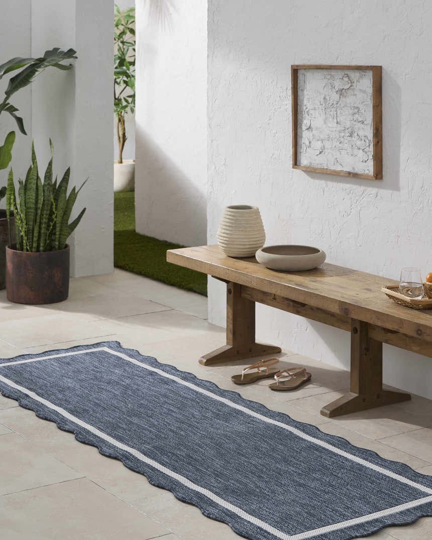 Hallway scene with a Varro Navy Area Rug runner, wooden bench, plants, and neutral decor. Roomscene-Runner