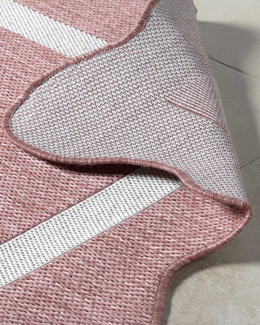 Close-up of the Varro Dark Pink Area Rug showing cream stripes, woven texture, and bound edge. Fold