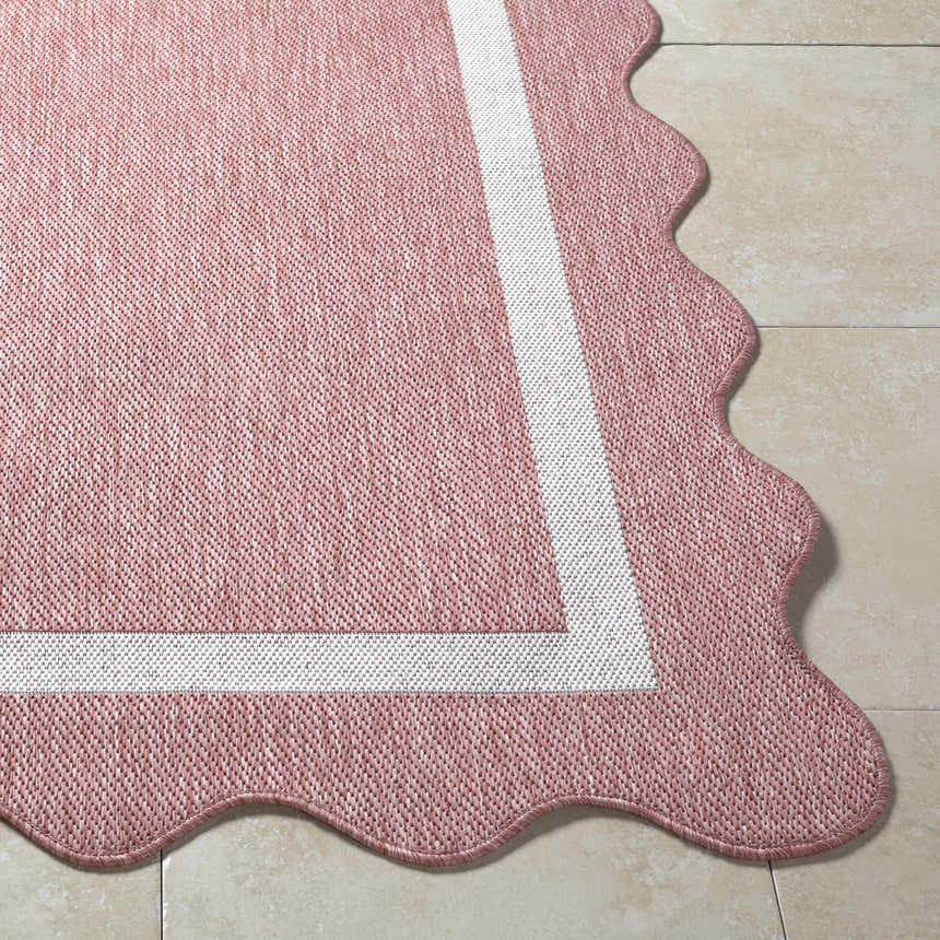 Close-up of the Varro Dark Pink Area Rug showing its cream border and unique scalloped edge detail. Front