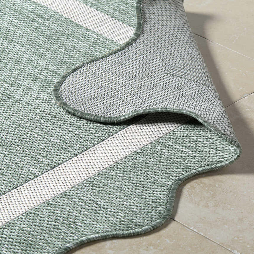 Close-up of the woven texture and cream stripes of the Varro Medium Green Area Rug. Fold