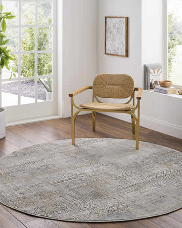 Sunlit home office with a round Owena Thick Luxe Boutique Rug in charcoal, cream, and light brown under a modern chair. Roomscene-Round