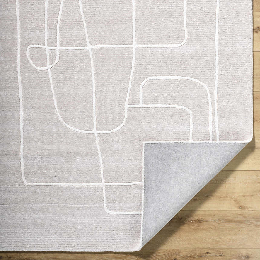 Close-up of Vatsa Gray Abstract Area Rug. Light silver wool rug with a geometric line design on a wood floor. Fold
