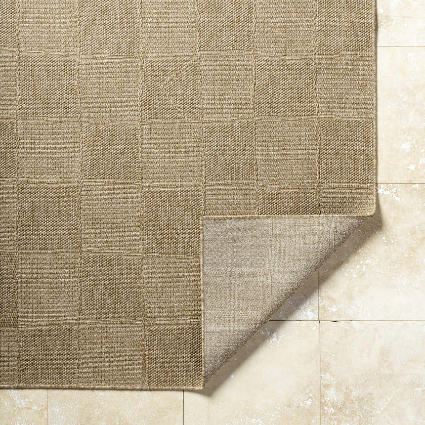 Close-up of the Veras Beige Area Rug showing its woven texture and geometric block pattern on a beige tile floor. Fold