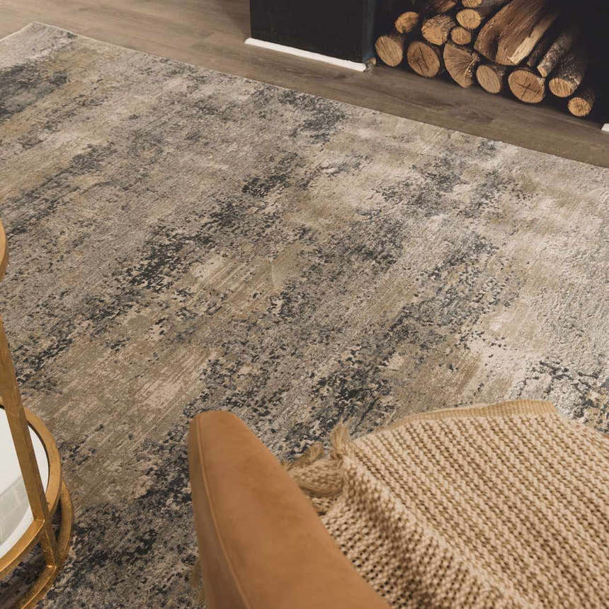 Living room scene with a neutral Whyalla Misty Thick Luxe Rug, tan chair, and fireplace with wood. Styleshot