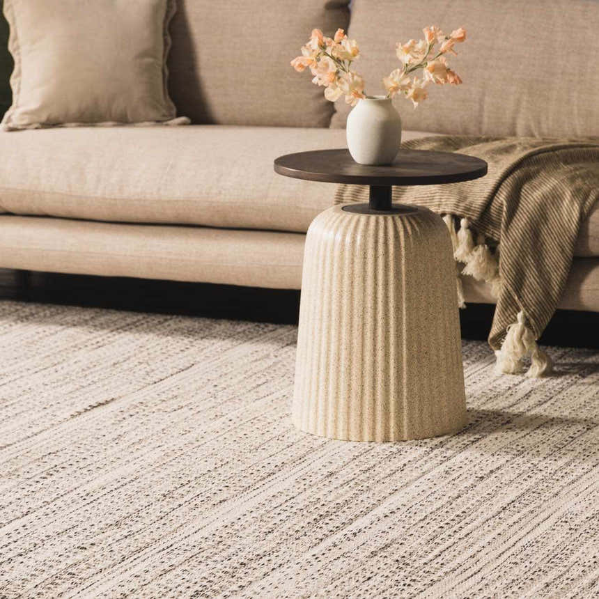 Living room scene with a cream sofa and the black and cream Williford Wool Area Rug, creating a cozy, transitional style. Styleshot