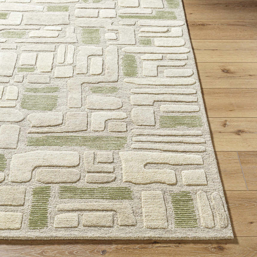 Close-up of the Alaqua Area Rug. Hand-tufted wool rug with a contemporary geometric pattern in ash, desert sand, and slate blue. Front