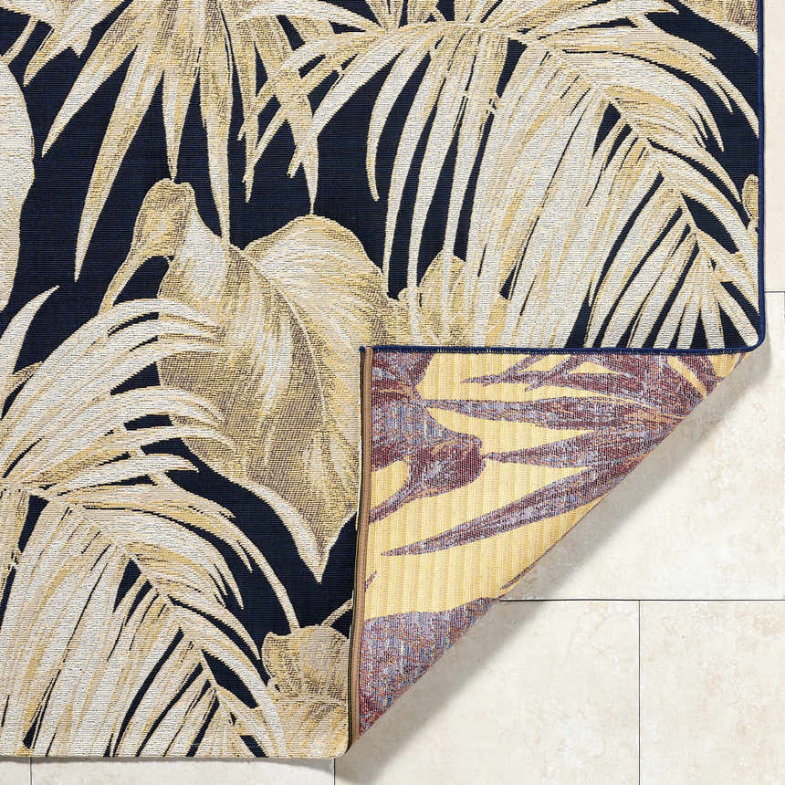 Close-up of Amirah Midnight Blue area rug showing the golden palm leaf pattern and the rug's backing. Fold