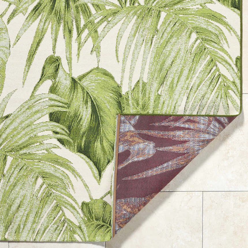 Close-up of the Amirah Green Area Rug featuring a tropical palm leaf pattern in ivory and olive hues. Machine woven texture. Fold