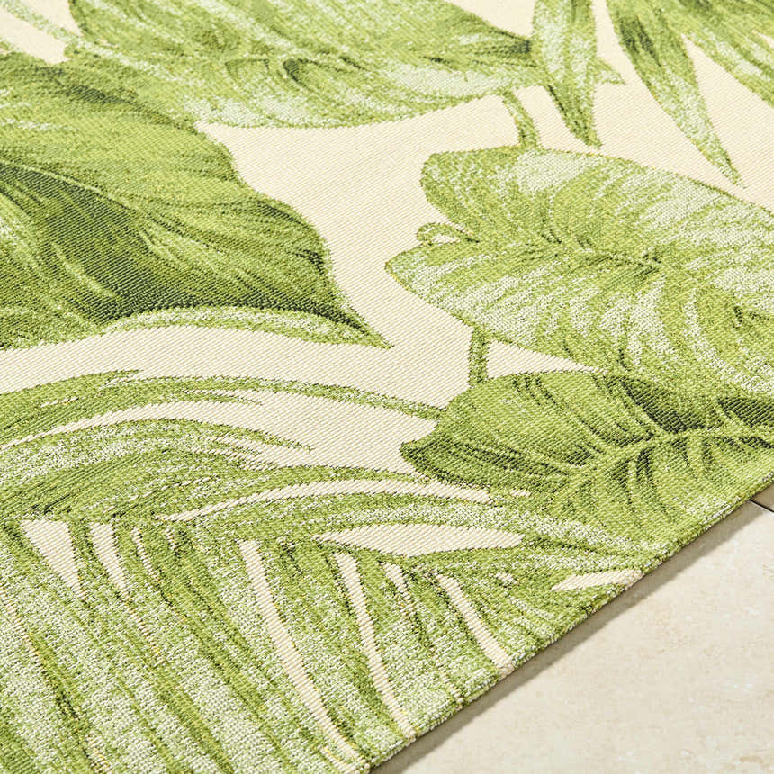 Close-up of the Amirah Green Area Rug featuring a tropical leaf pattern in olive and ivory. Texture