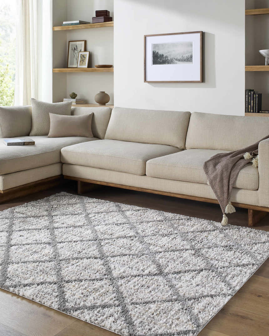 Living room with a neutral sectional and the Anuhea Off White area rug featuring a geometric pattern. Roomscene-Rectangle