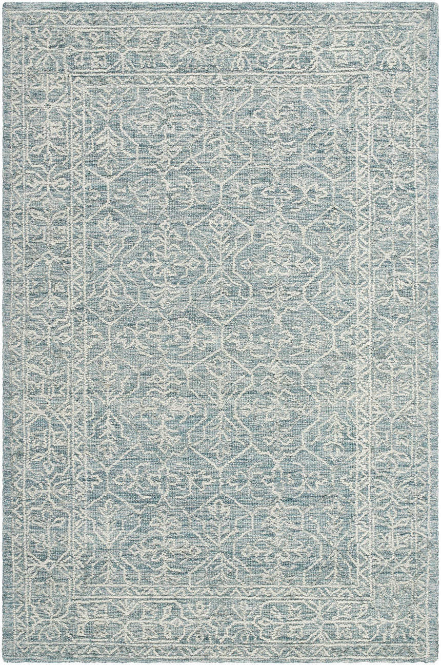 Close-up of the Yadid Area Rug. Hand-tufted wool rug in light blue with a traditional white floral pattern and border. Design-Rectangle-576