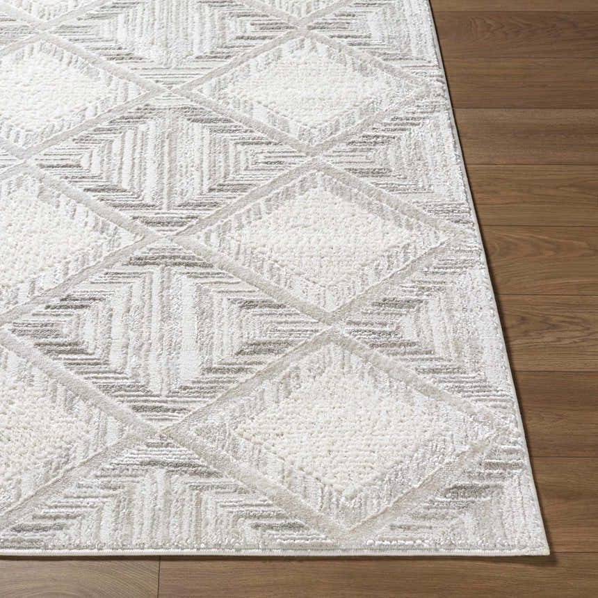 Close up of the Yayoi Area Rug showing its cream, ivory, and gray geometric diamond pattern and soft texture. Front