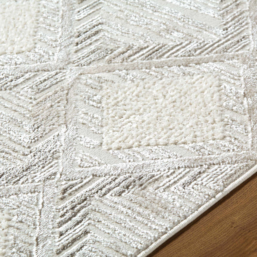 Close up of the Yayoi Area Rug showing its cream, ivory, and gray geometric pattern and soft texture. Texture