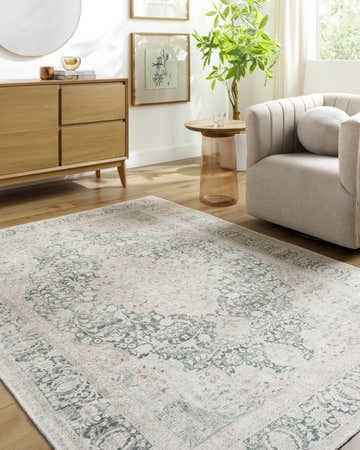 Living room scene with a cream armchair and the cream and green Yanis Vintage Flat Pile Washable Rug. Roomscene-Rectangle