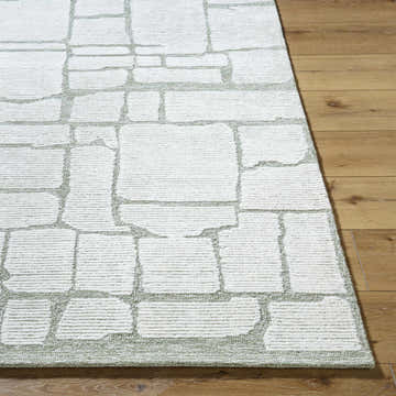 Close-up of the Yetty Sage Area Rug showing its ivory and sage geometric pattern and hand-tufted wool texture. Front