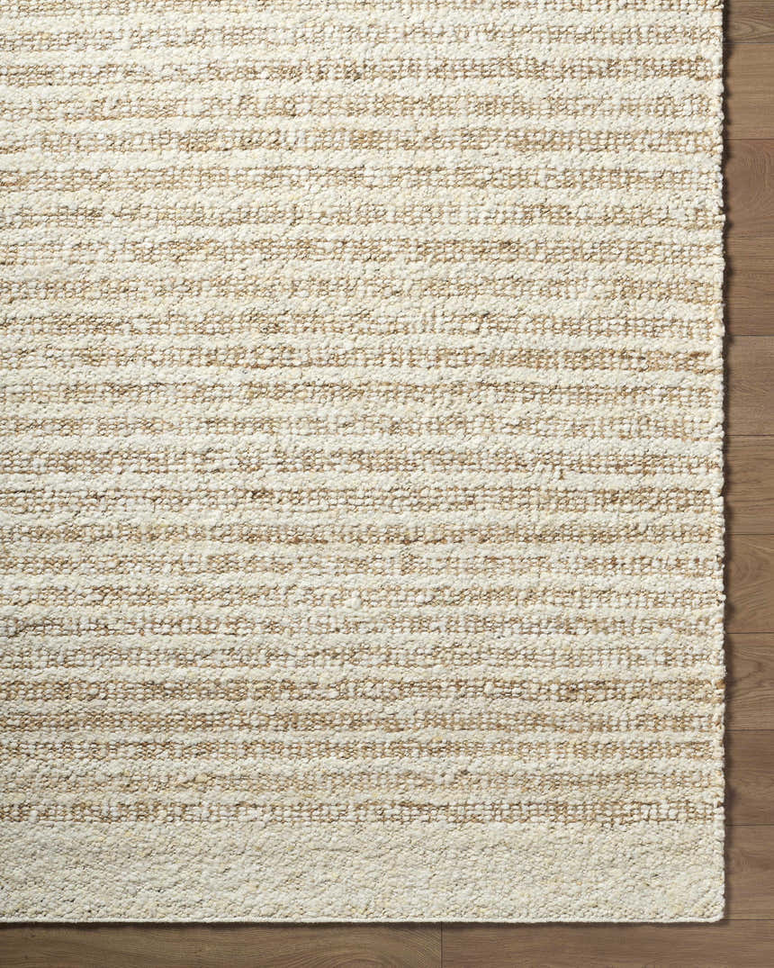 Close-up of the hand woven Yaron Area Rug showing its pearl and tan jute and wool striped texture. Corner