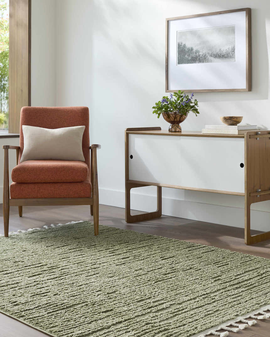 Living room scene with olive Annily Area Rug, orange chair, and modern white cabinet. Roomscene-Rectangle