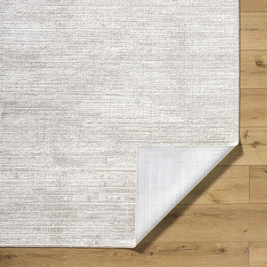 Close-up of the Arnulf 3D Textured Washable Rug in cream, ivory, and taupe, showing the textured design and non-slip backing. Fold